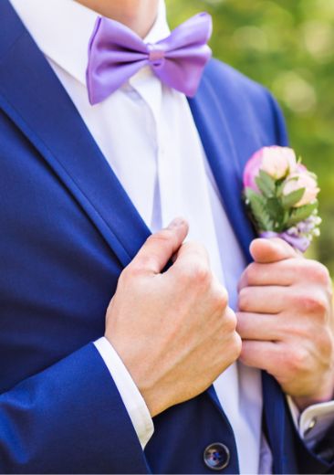 blue suit with purple bow tie