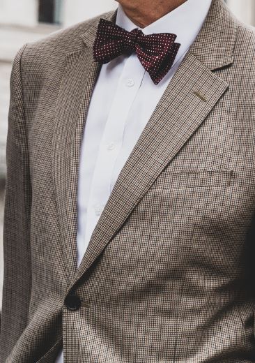 grey patterned suit with dark red bow tie